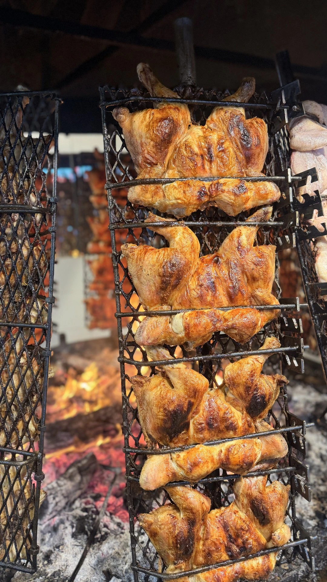 Pollos cocinándose en el asador de El Brasero, junto al fuego y las brasas