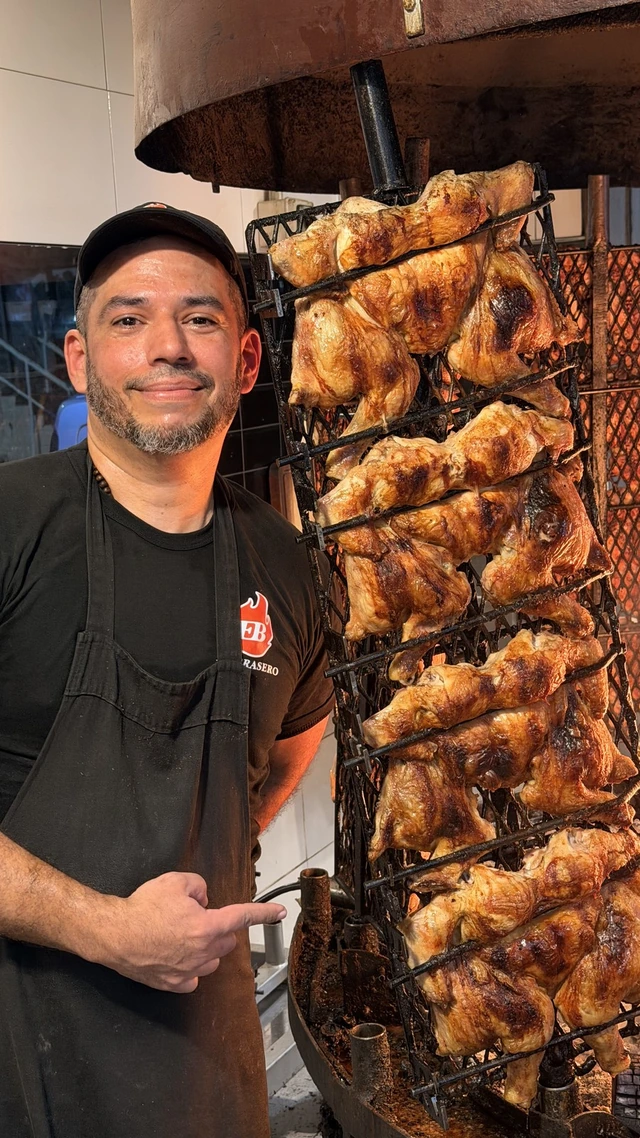 Integrante de El Brasero junto a los asadores de pollo
